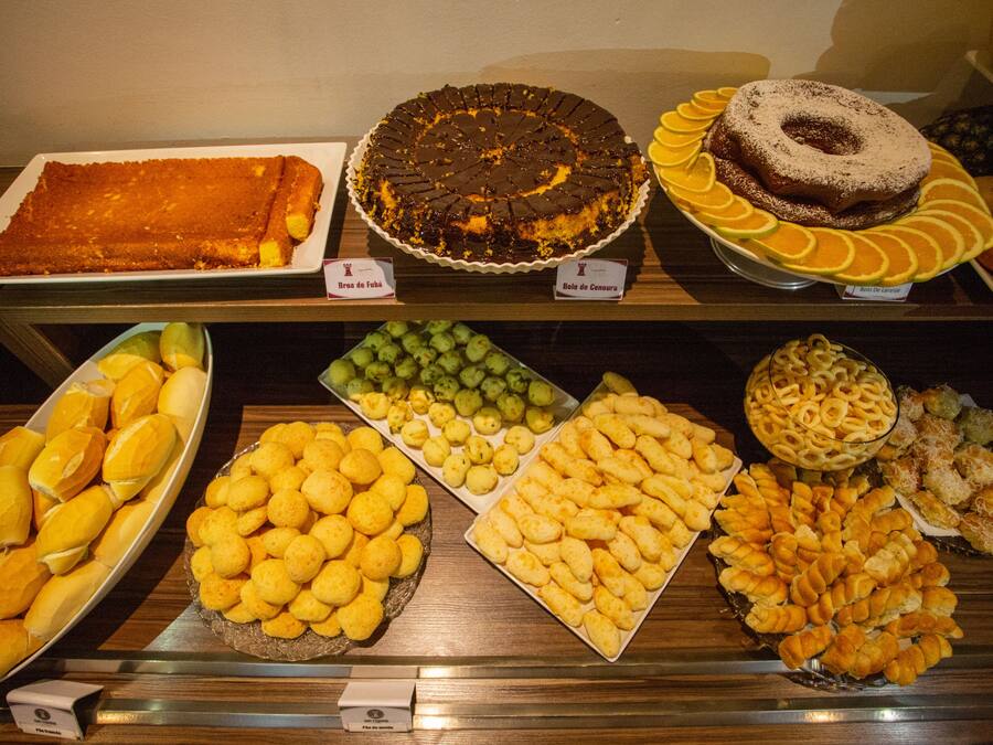 En buffet med forskellige spiser, heriblandt kager, wienerbrød og brød.
