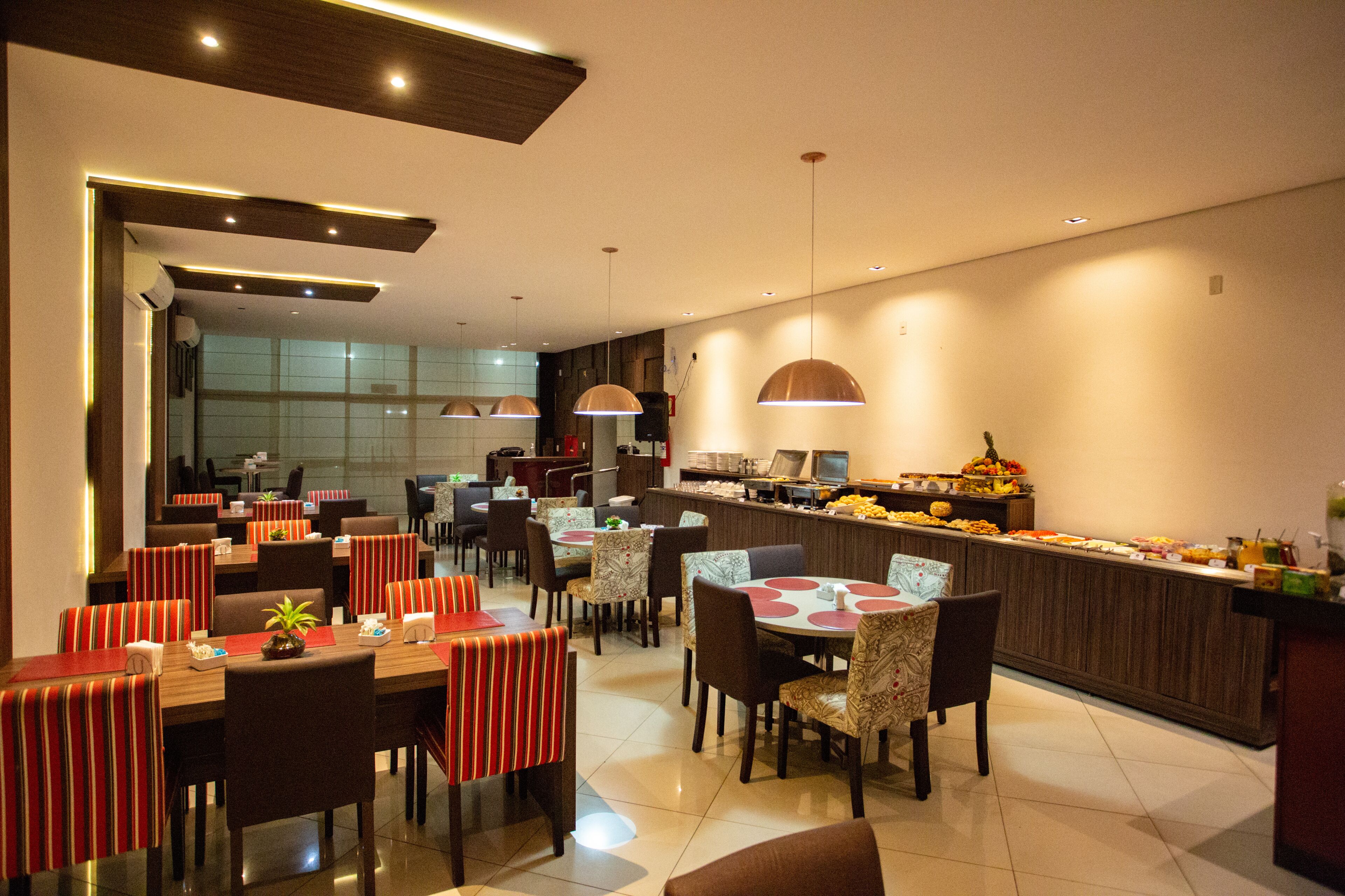 Ein modernes Restaurant mit mehreren Essbereichen, einer Bar und einem Buffet.