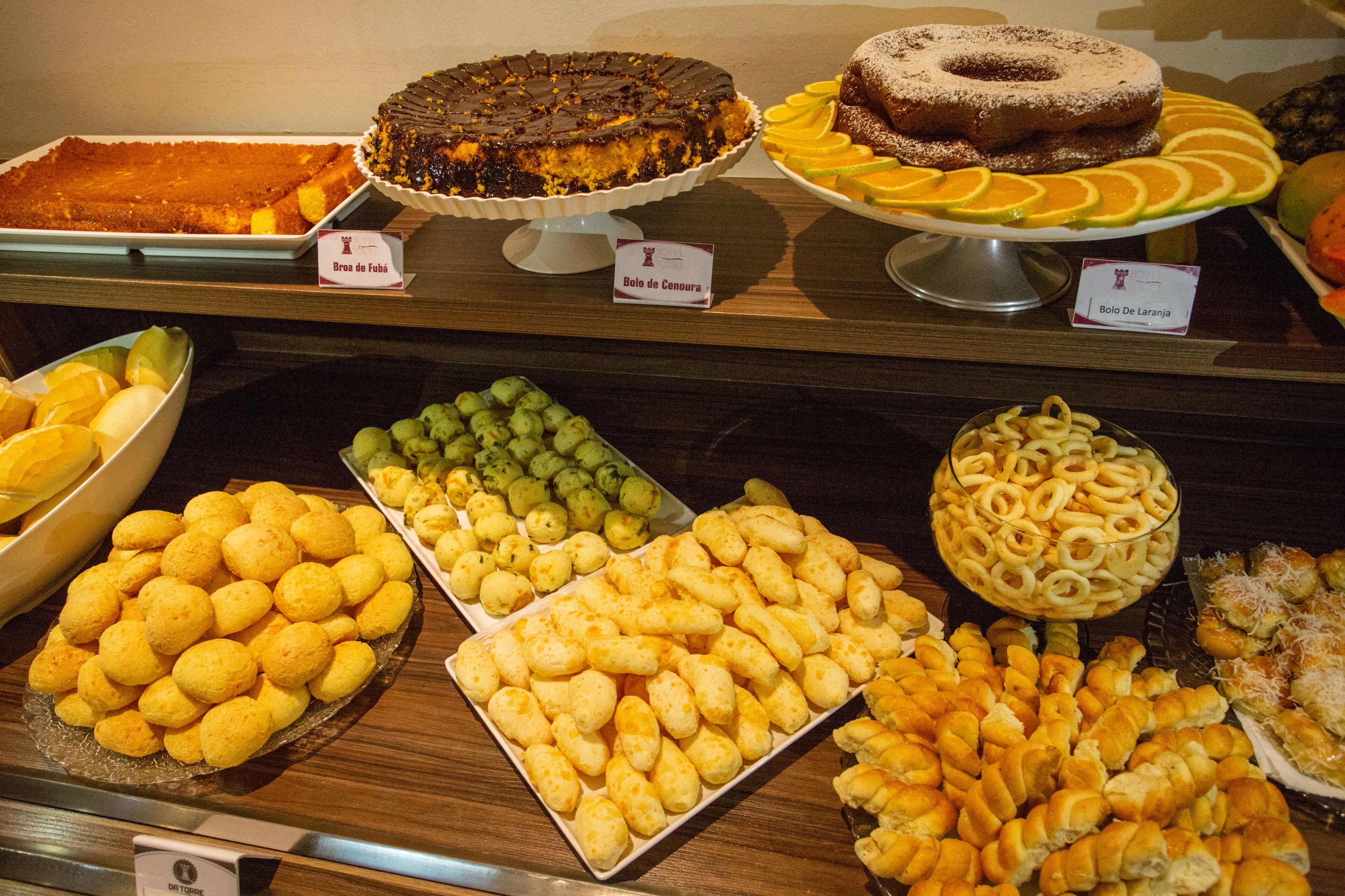 A buffet with various dishes including a chocolate cake, donuts, and assorted snacks.