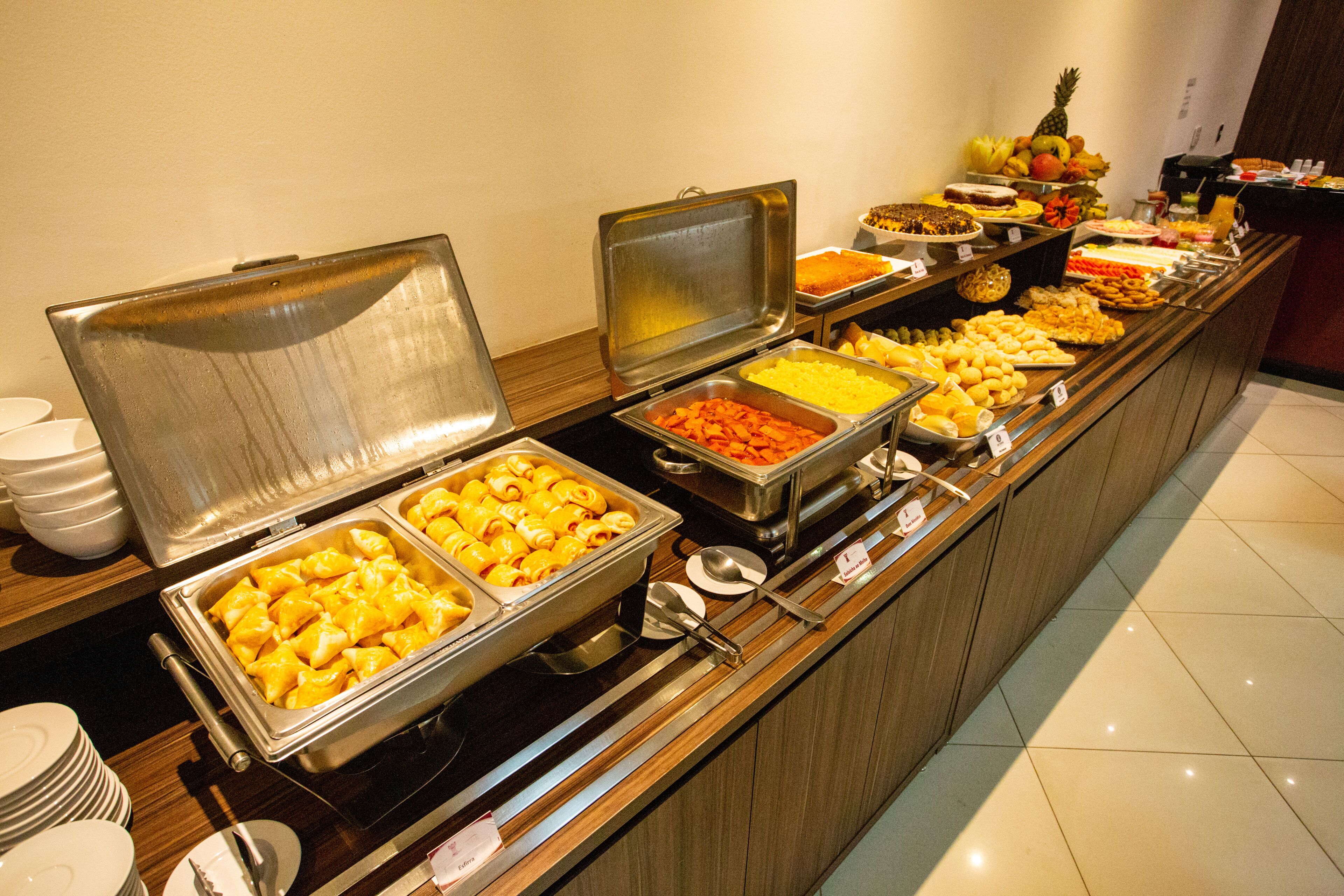 A buffet with various food items and utensils.