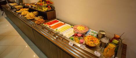 A buffet with various food items and beverages.
