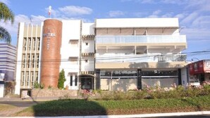 Un hotel con una torre cilíndrica destacada, una fachada plana y un balcón en el nivel superior.