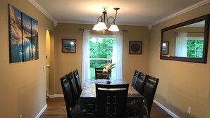 A dining room with a large table, chairs, a chandelier, and artwork on the walls. - 6BR Family Retreat - Heated Pool & Game Room - Near Lake George & Saratoga (Corinth)
