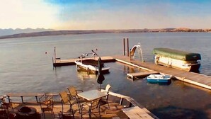 Un muelle con barcos, un vehículo cubierto y un área de estar con sillas y una mesa.
