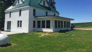 A two-story white house with a green roof and a covered porch. - Shady Pines Retreat  (Ontario)