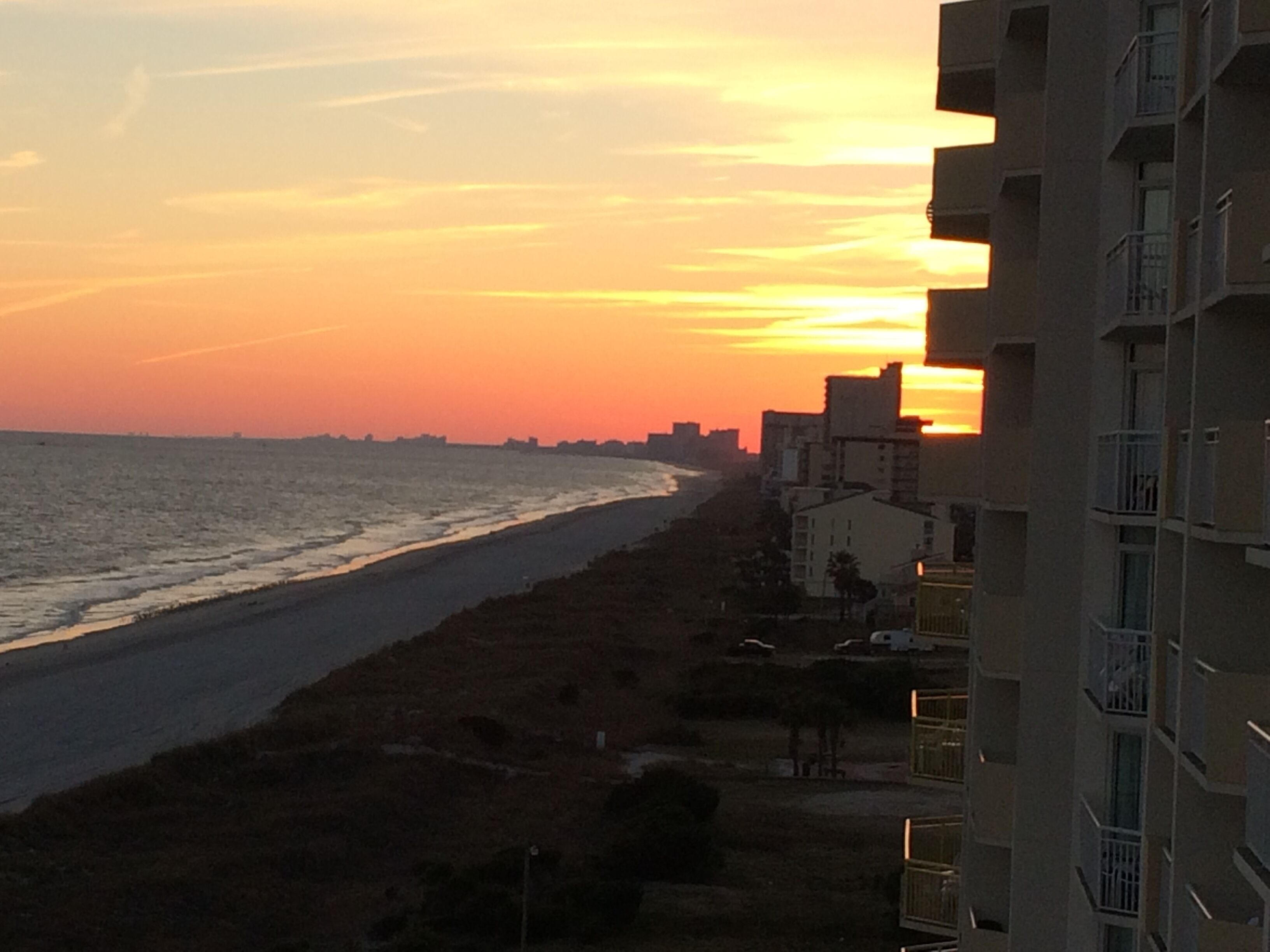 A coastal view with a beach and buildings.