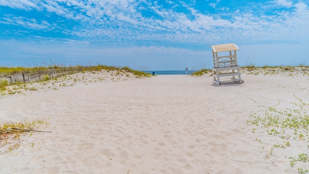 Une plage avec un poste de surveillance pour les sauveteurs et une vue dégagée sur l’océan.