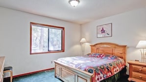 A bedroom with a bed, two bedside tables, a window, and a door. - Yosemite Pines (Yosemite)