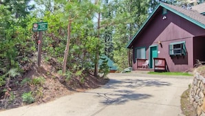 A red building with a green roof, a porch with chairs, and a sign indicating 'Yamaska Pines 7292'. - Yosemite Pines (Yosemite)