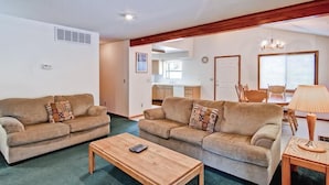A living room with two sofas, a coffee table, and a dining area with a table and chairs. - Yosemite Pines (Yosemite)