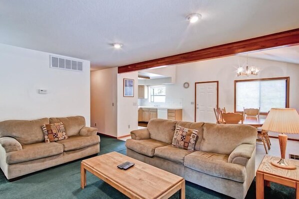 A living room with two sofas, a coffee table, and a dining area with a table and chairs. - Yosemite Pines (Yosemite)