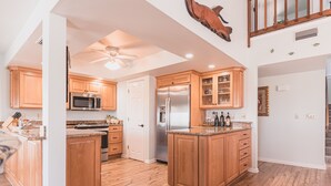 Una cocina amplia con armarios de madera, un refrigerador de acero inoxidable y una encimera de granito.
