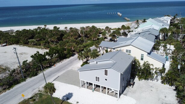 Propiedad costera con varias construcciones, una playa y una carretera.