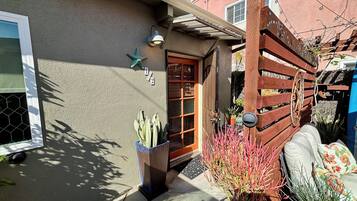 A residential house with a wooden door, a starfish decoration, and a potted plant.