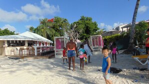 Un bar in riva al mare con posti a sedere all'aperto e un piccolo palco.