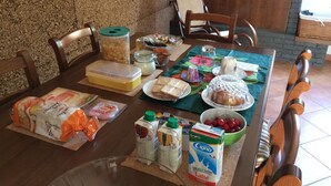 A dining table with food items, a milk carton, and a coffee maker. - B&B Lotus House (Lanciano)