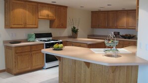 Una cucina moderna con mobili in legno, un'isola centrale e un piano cottura.