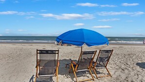 A beach with two wooden beach chairs and a blue umbrella. - Hilton Head Tennis Villa  (Hilton Head Island)