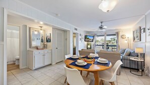 A dining area with a round table, chairs, and a ceiling fan. - Hilton Head Tennis Villa  (Hilton Head Island)