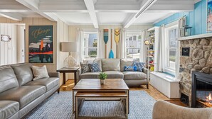 A living room with a stone fireplace, leather sofas, a coffee table, and a cityscape poster. - 100 steps to Lake Michigan beach, private courtyard. Book Notre Dame wknds now! (Michigan City)