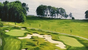 Un parcours de golf avec des bunkers de sable et des arbres.