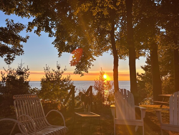 A sunset view with a beach and chairs.