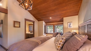 A bedroom with two beds, a wooden ceiling, a window with a view of trees, and a framed picture on the wall. - Perfect Family Getaway With A/C - Location! Location! (Homewood)