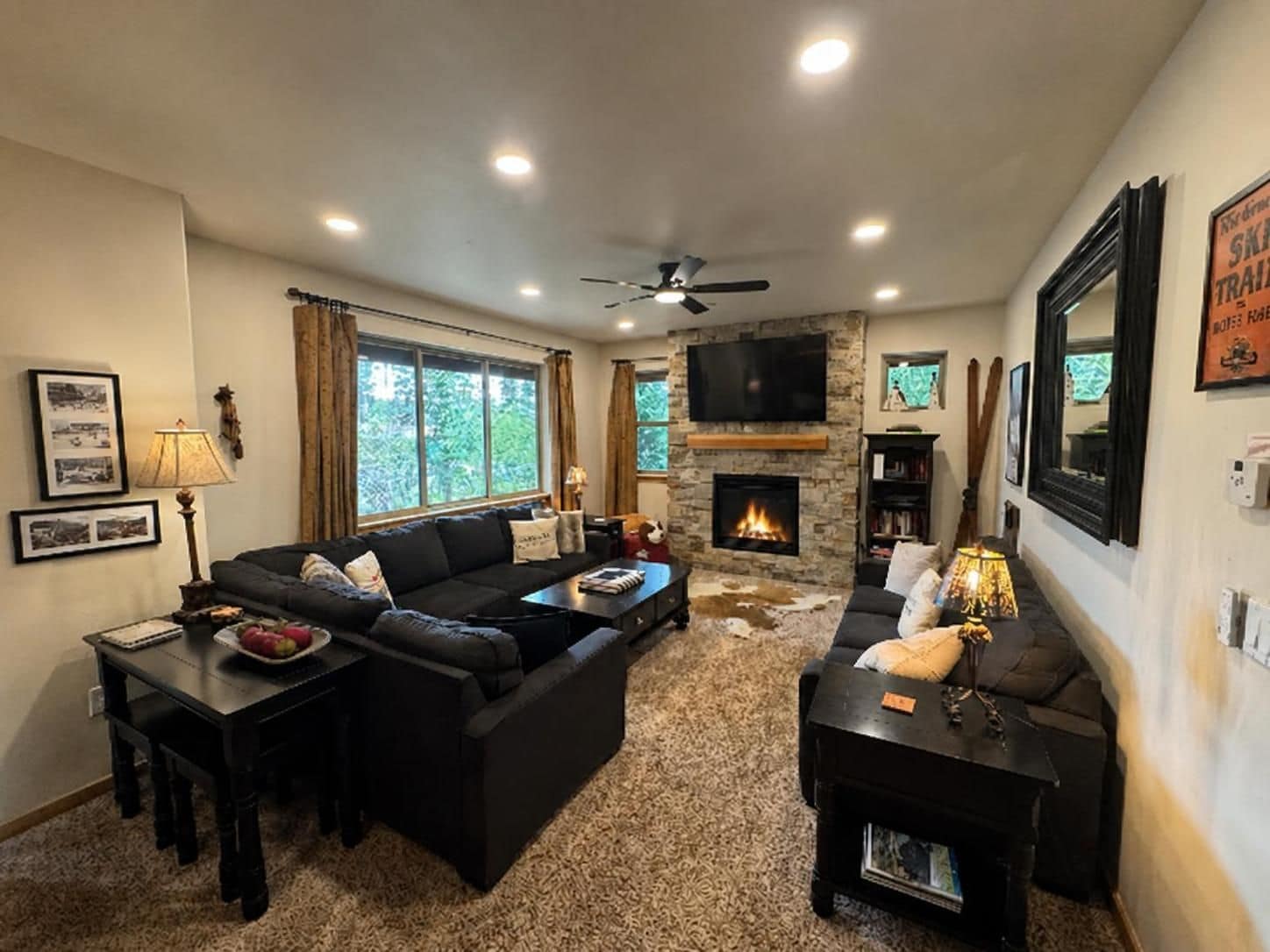 A living room with a fireplace, a sofa, a coffee table, and a television mounted on the wall.
