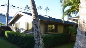 A residential house with a sloped roof, a well-maintained lawn, and a hedge.