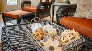 A wicker basket filled with decorative items on a wicker sofa.