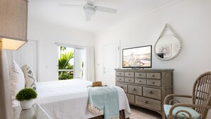 A bedroom with a bed, dresser, chair, and a television. - Gorgeous second floor, ocean front with huge wrap around balcony!!! (Providenciales)