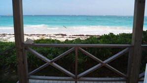 Una terraza de madera con vista a una playa y al océano.