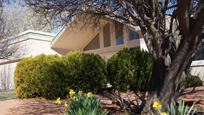 A modern house with a sloped roof, surrounded by well-maintained bushes and a tree. - Starlight Villa of Sedona - 10% WEEKLY Discounts (Sedona)