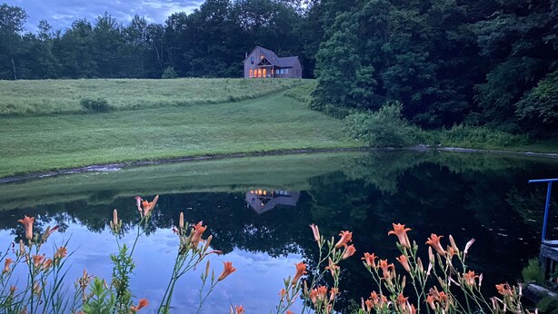A house with a pond in front, surrounded by greenery. - Family-Friendly Home With Incredible Berkshire Views And A Private Swim Pond (Stephentown)