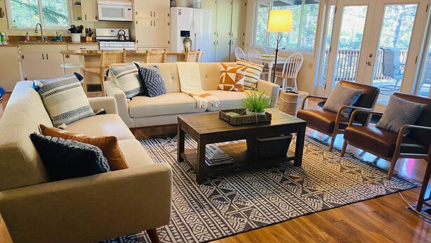 A cozy living room with a sofa, armchairs, a coffee table, and a dining area with a table and chairs. - Starview Lodge: Quiet Mountain Home Bordering State Forest (Cobb)