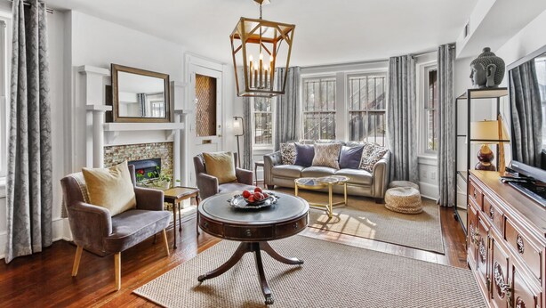 A spacious living room with a sofa set, a coffee table, and a television on a wooden cabinet.