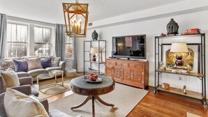 A living room with a sofa, coffee table, TV, and decorative items.