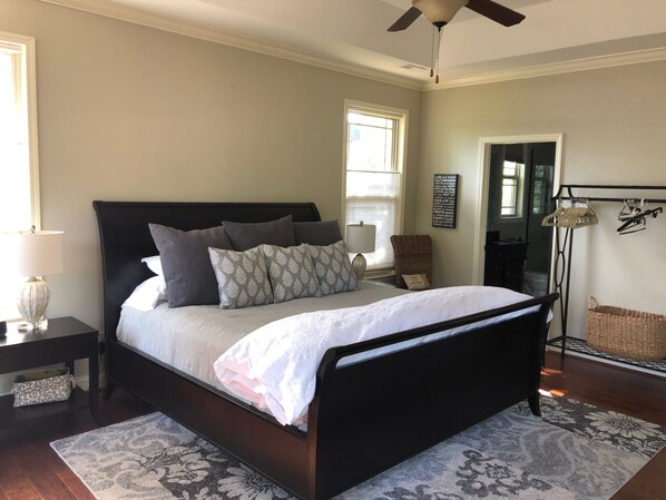 A bedroom with a large bed, a nightstand, a lamp, a chair, a floor lamp, and a wall with motivational quotes. - Lakefront Lake Keowee Home with flat lawn & private dock. 14 miles to Clemson! (Seneca)
