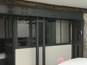 A room with a metal bar structure, a white wall, and a pink chair. - QUIET RENOVATED INDUSTRIAL LOFT IN "GRANDS BOULEVARDS" AREA; PARIS THEATRES AREA (Paris)