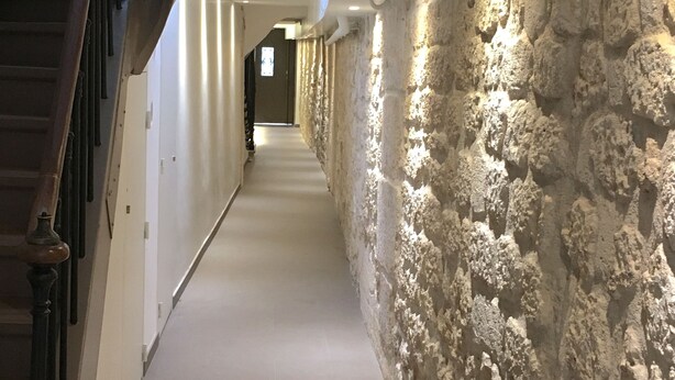 A hallway with a stone wall on one side and a wooden staircase on the other. - QUIET RENOVATED INDUSTRIAL LOFT IN "GRANDS BOULEVARDS" AREA; PARIS THEATRES AREA (Paris)