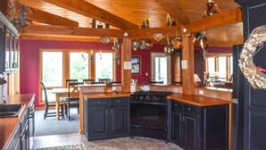 Una cocina con vigas de madera, una isla central y una estufa.