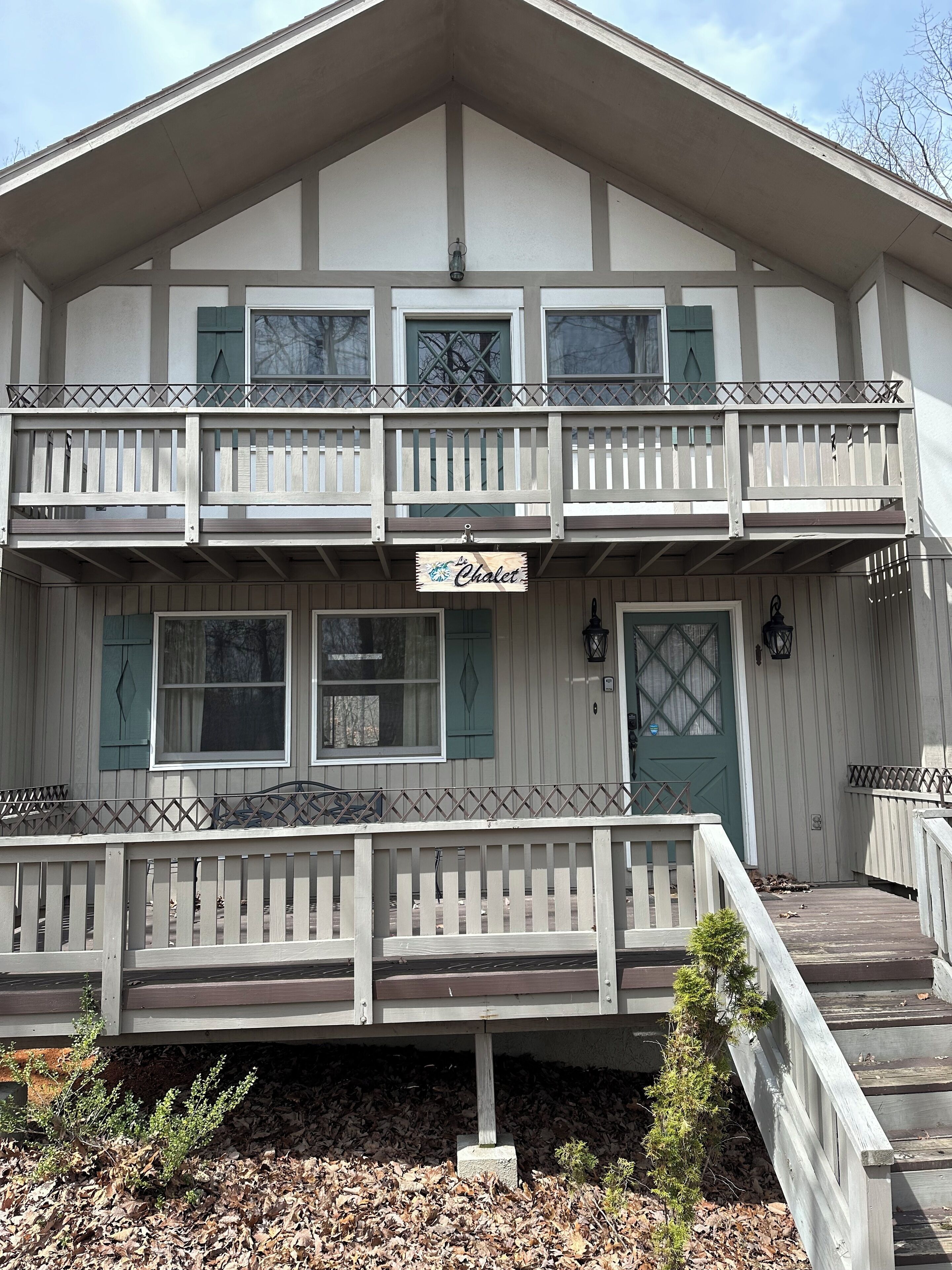 A two-story building with a balcony and a sign that reads "The Chalet".
