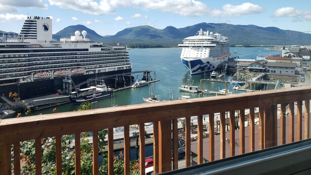 Un navire de croisière était amarré dans un port, avec des montagnes en toile de fond.