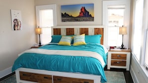 A bedroom with a bed, two nightstands, a window, and artwork on the walls. - Casa Rustica - Centrally located, Carlsbad Caverns (Carlsbad)