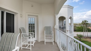 Enjoy a peaceful retreat with a balcony offering a view of the surrounding residential area and palm trees.