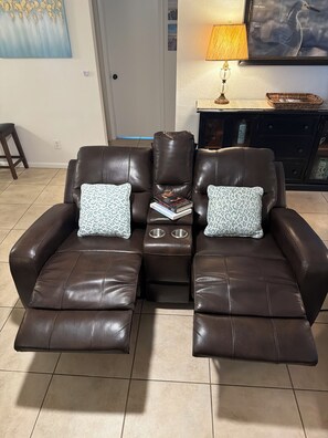 A brown leather sofa with two side tables, each with a book and a patterned pillow. - Hot Tub, Salt Air & Sunsets Your Naples Beach Retreat (Naples)