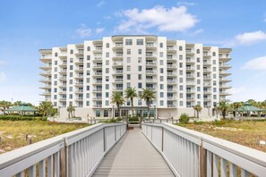 A multi-story hotel with a central courtyard, balconies, and a beachside location.