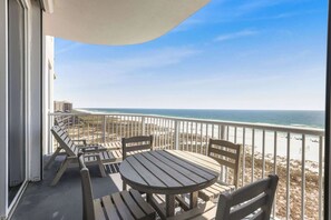 A balcony with a view of the beach and ocean.