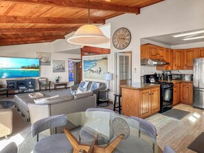 Relax in this spacious living area with a large flat-screen TV, comfortable sofa, and dining table.