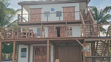 A two-story building with a wooden facade, multiple balconies, and a sign indicating Belize.